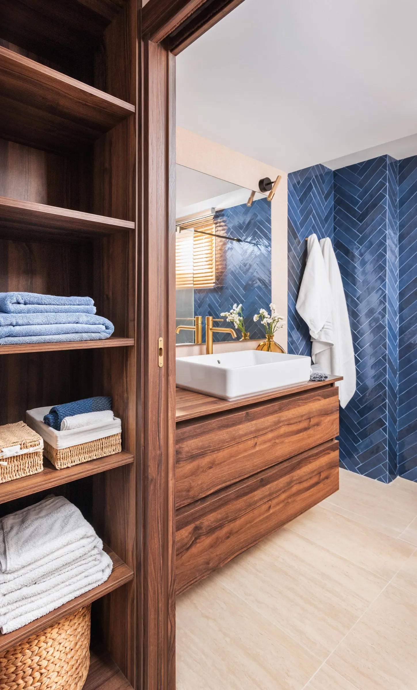 Mueble de baño en nogal con veta marcada y azulejos en azul.