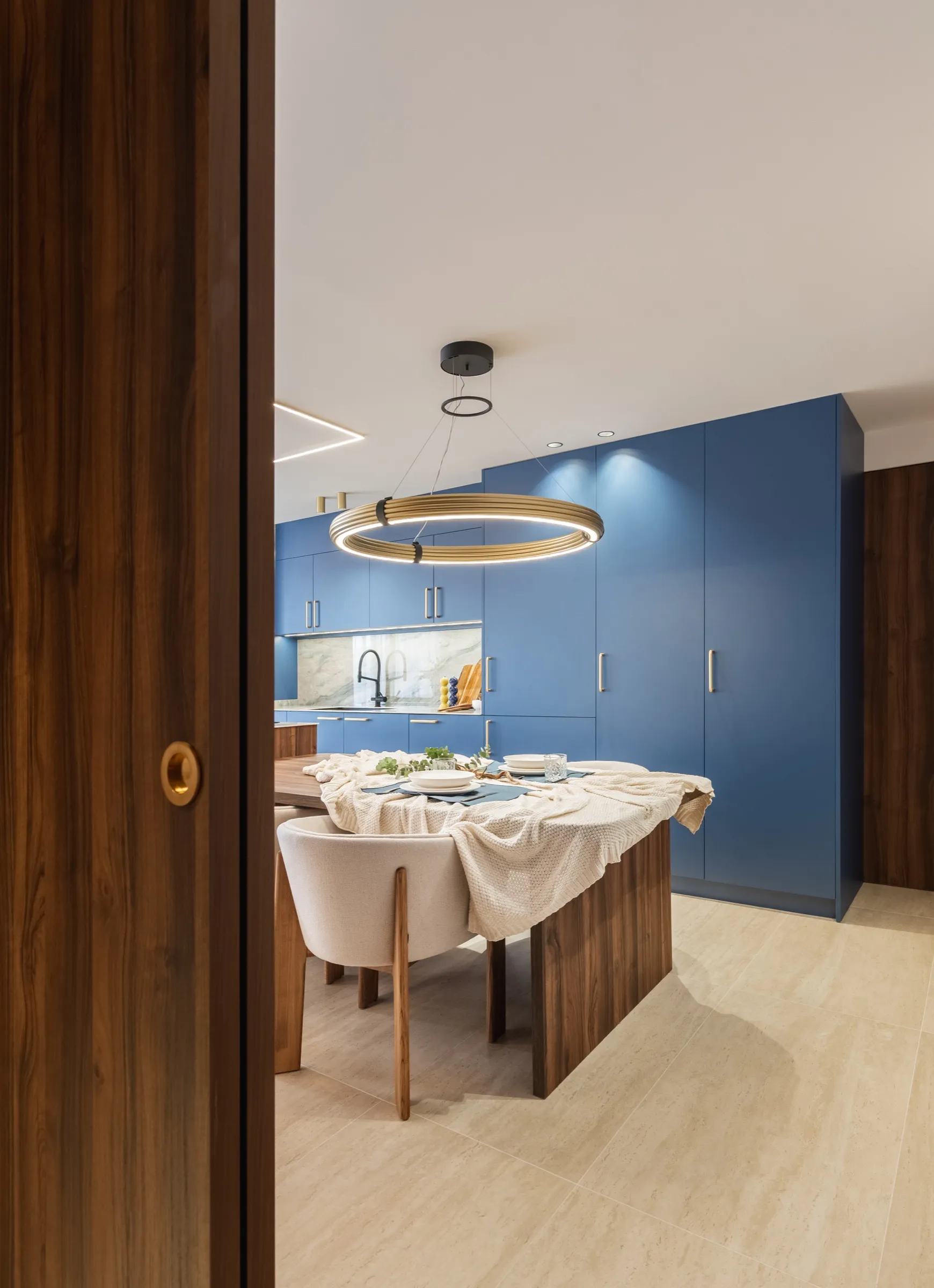 Dining room with circular gold pendant next to the kitchen
