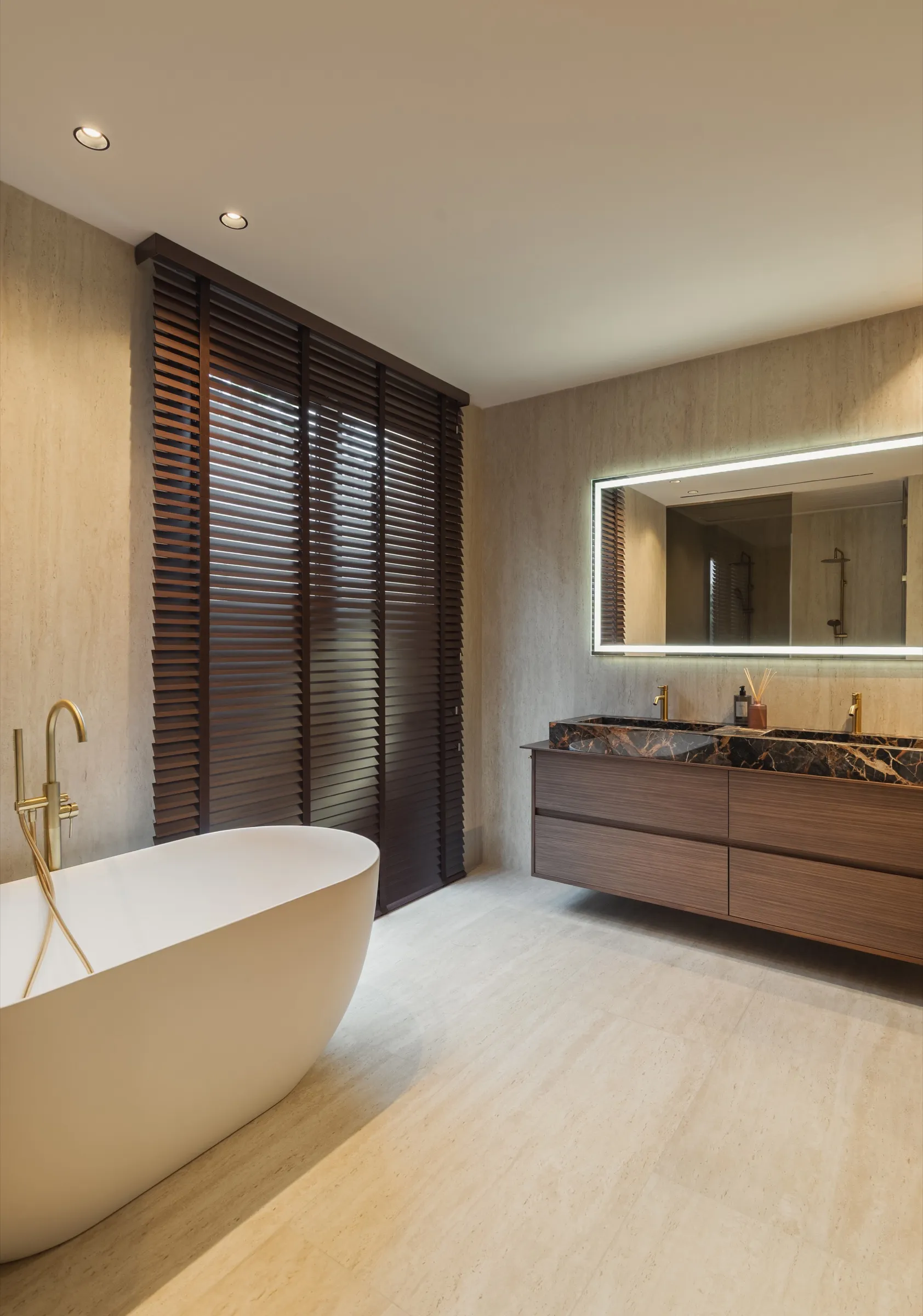 Baño con bañera exenta, mueble de madera suspendido y persianas de madera