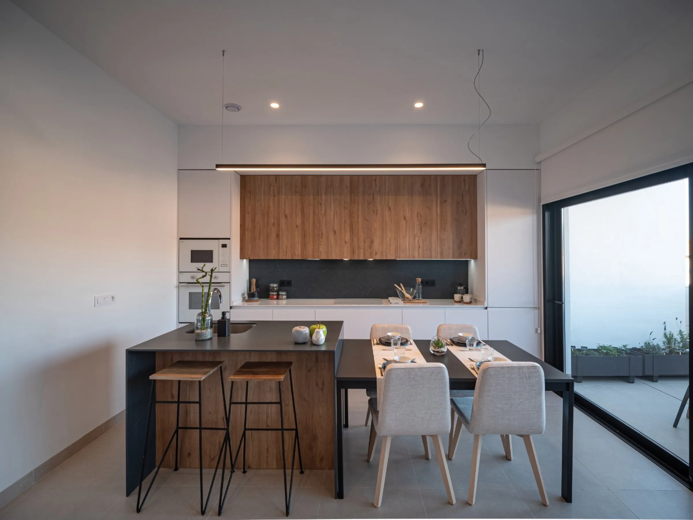 Cocina a medida en madera oscura con isla central blanca