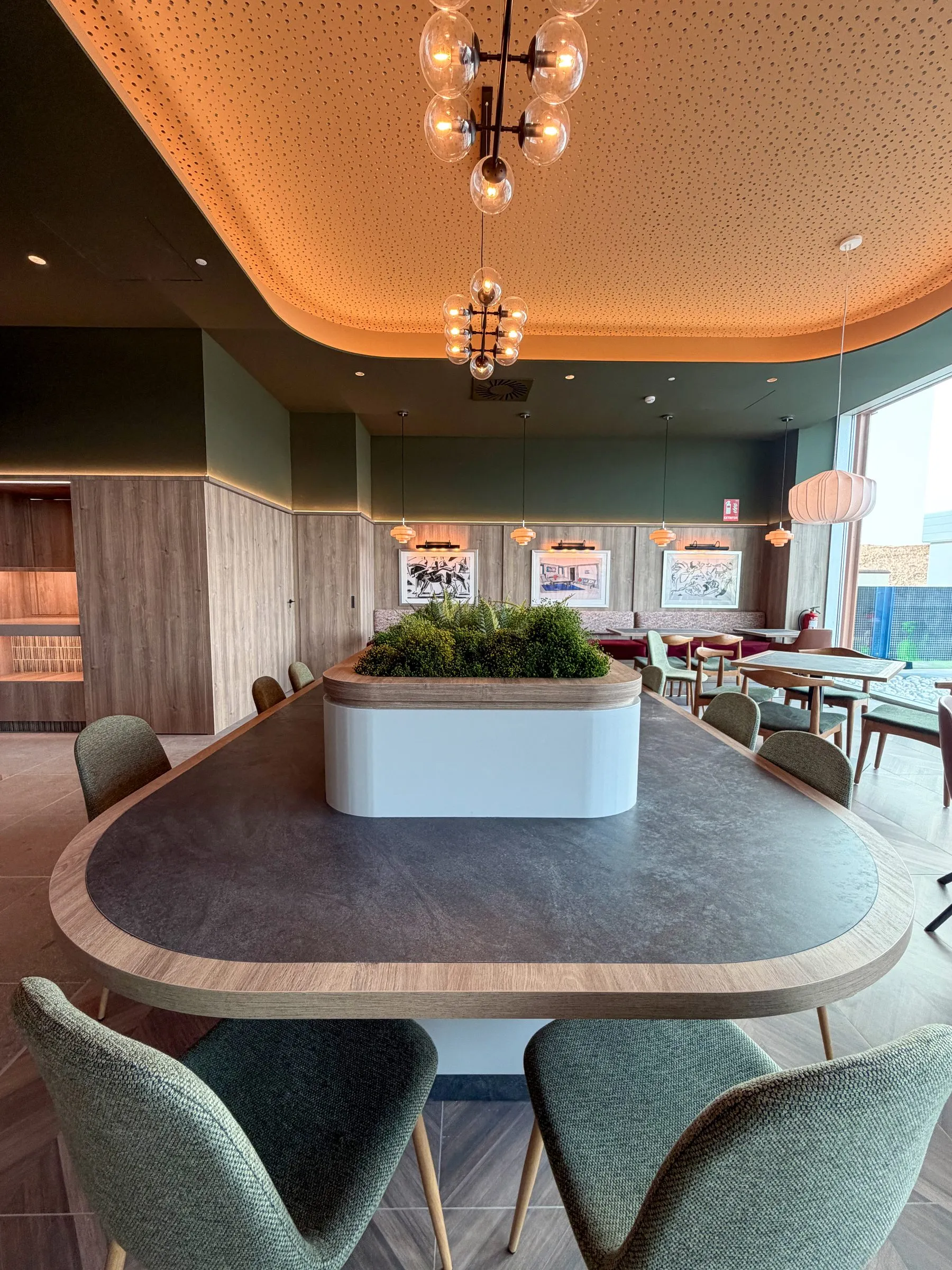 Mesa oval de madera bajo el techo curvo iluminado de la recepción