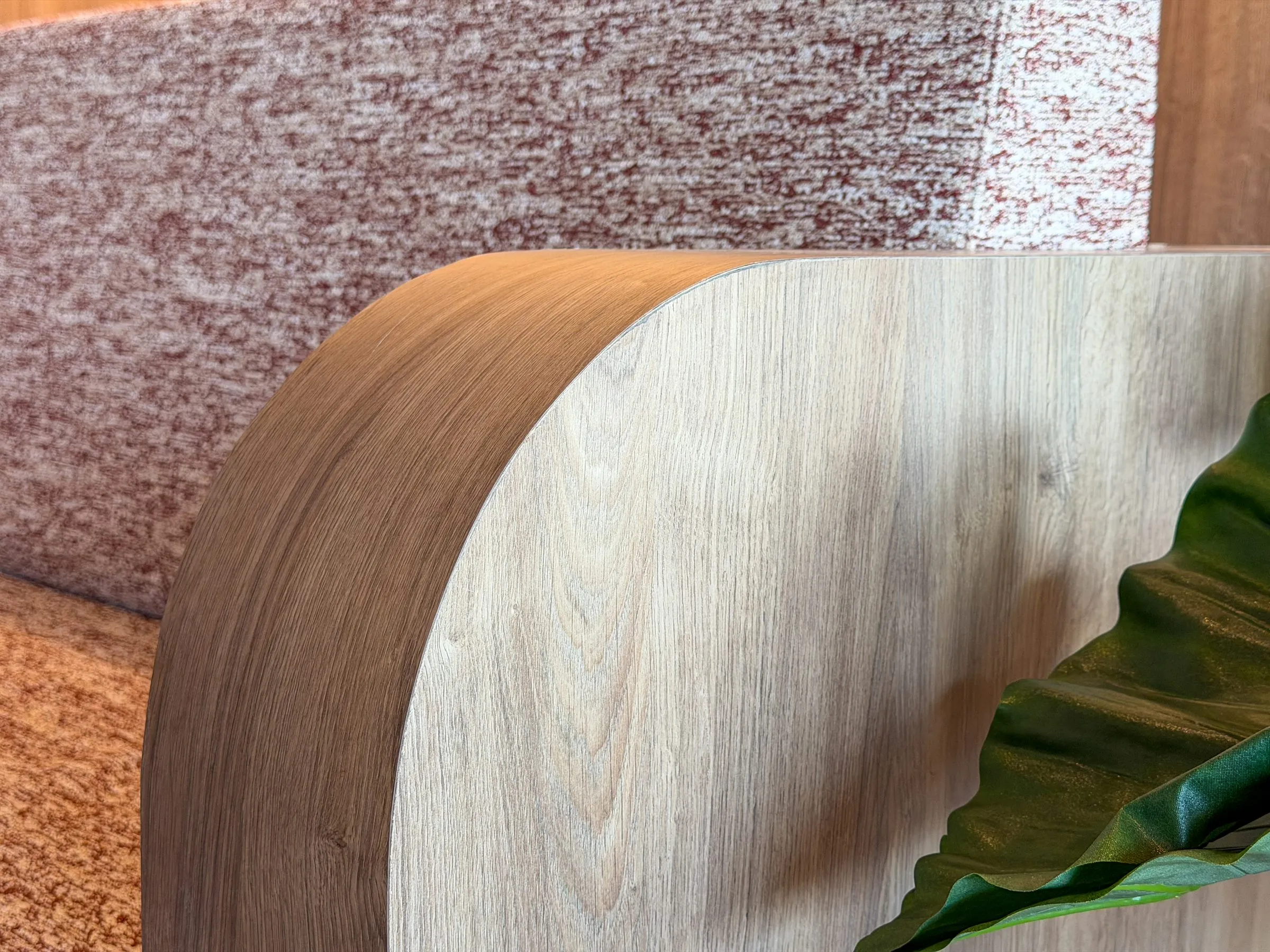 Detalle del remate curvo en madera del banco tapizado