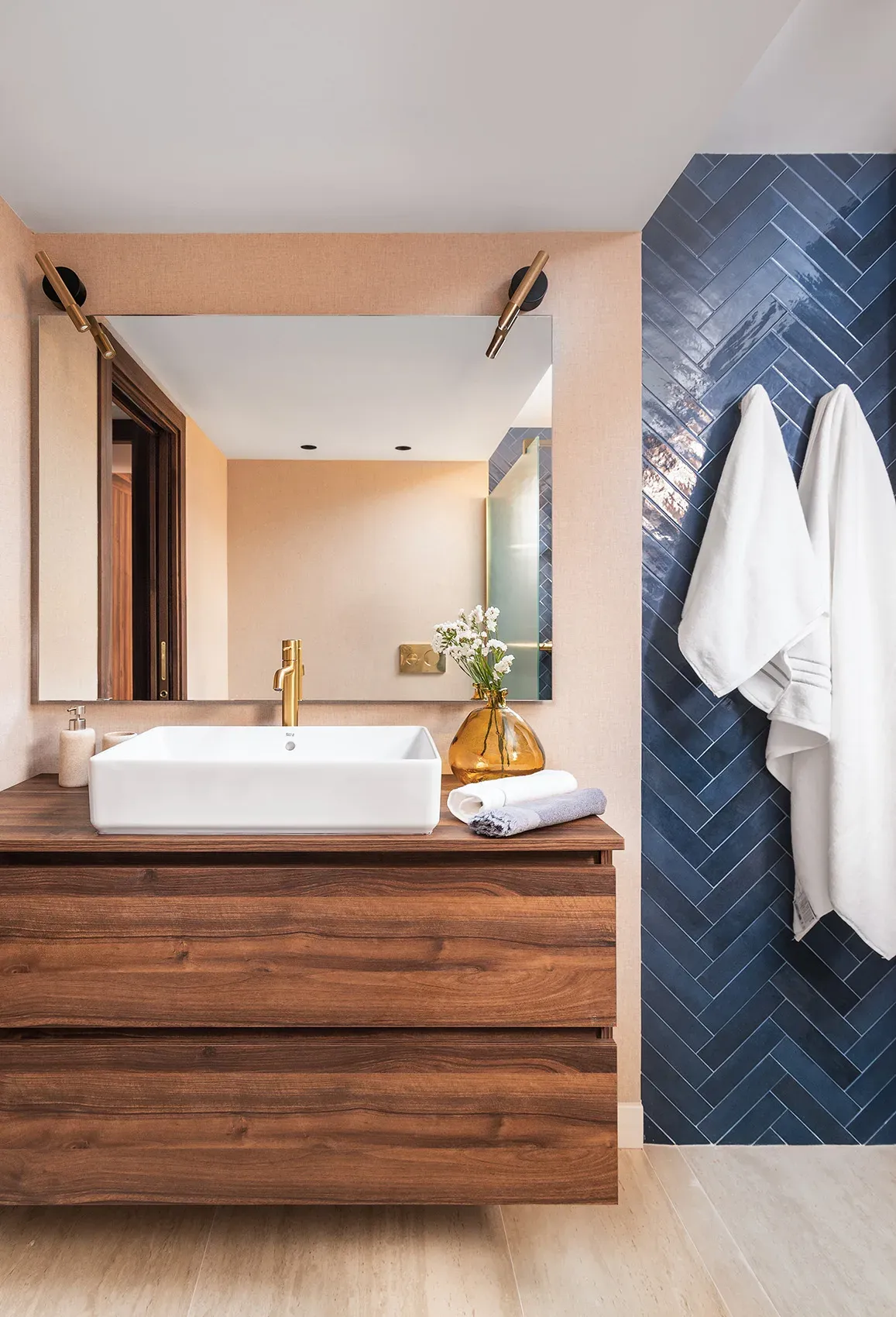 Frentes del mueble de baño en nogal, lavabo blanco y grifo dorado