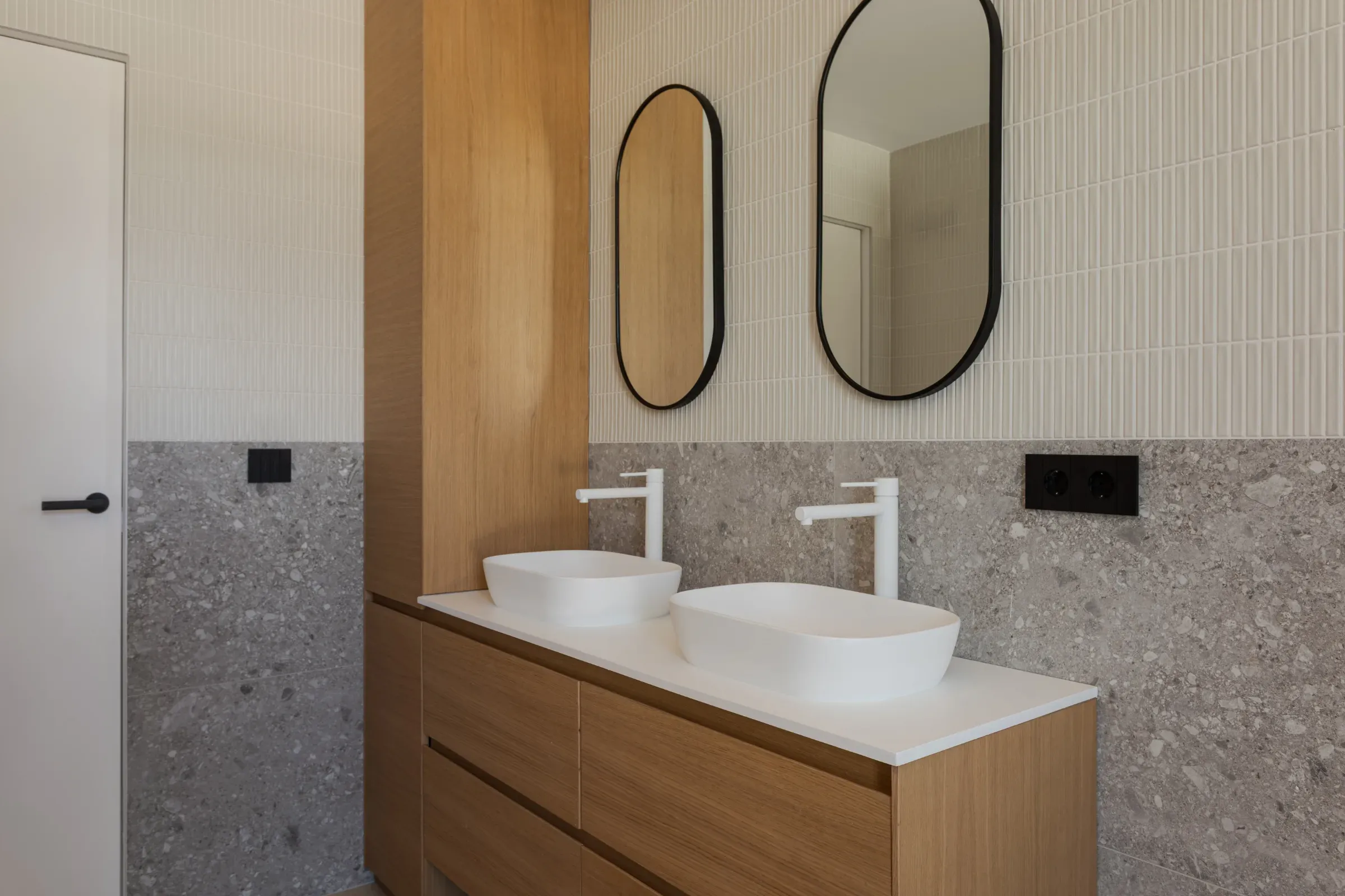 Baño en roble con módulo vertical y pared en azulejos y granito