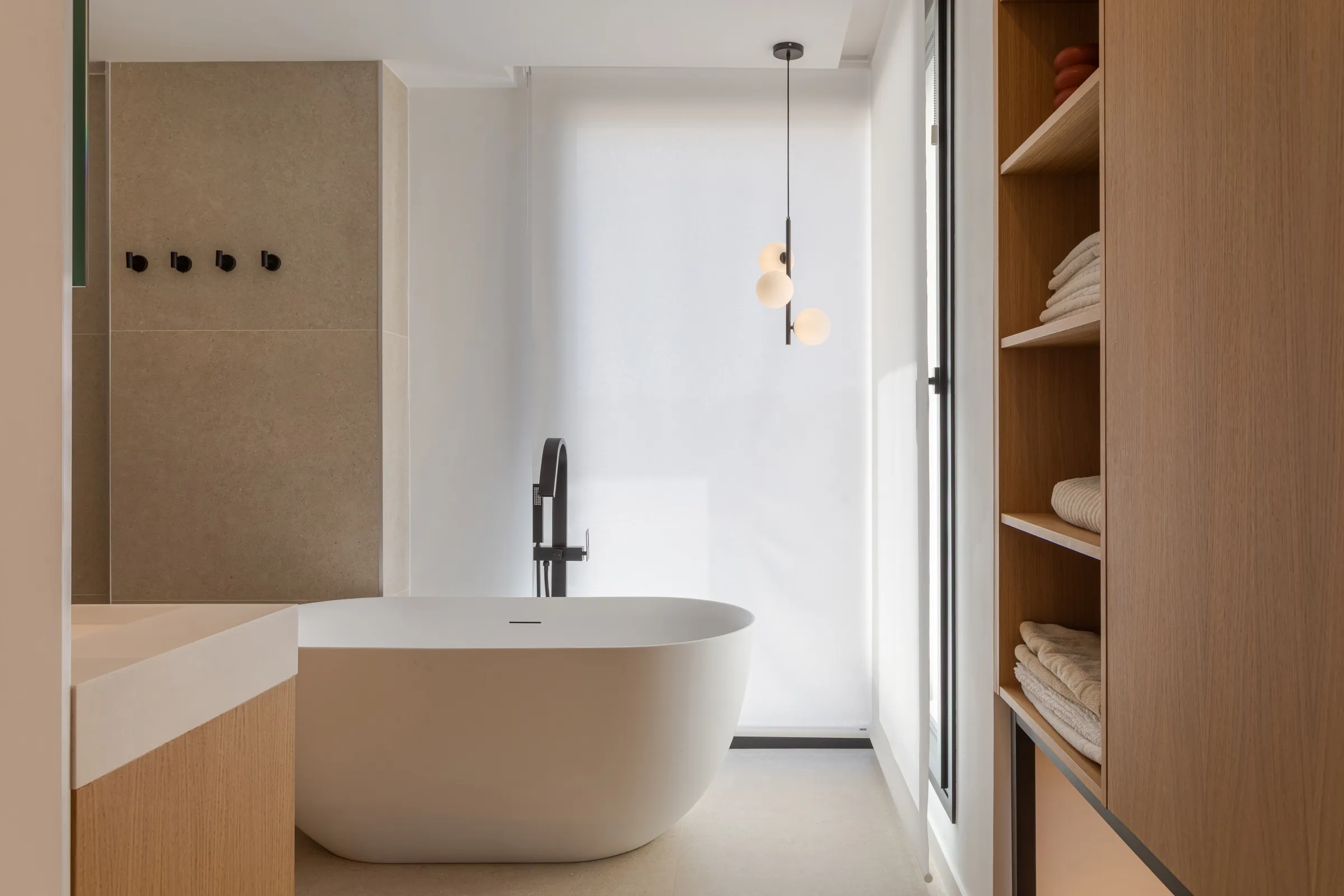Baño en el dormitorio principal con bañera y mobiliario de roble