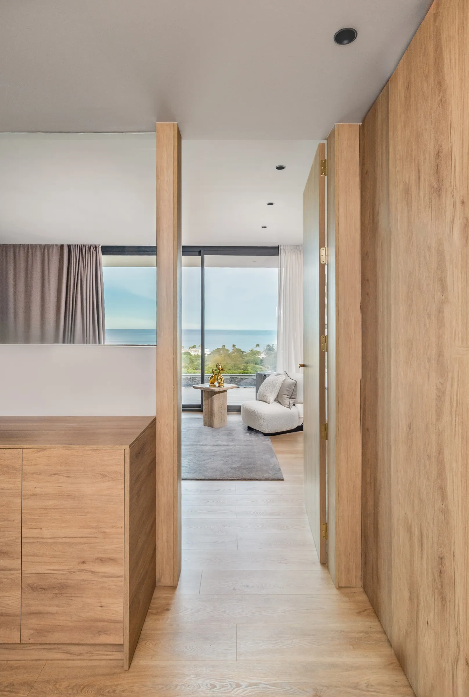 Pasillo con armarios de madera a medida y vistas al mar